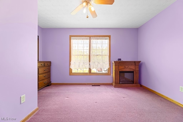 unfurnished living room featuring a textured ceiling, light colored carpet, and ceiling fan