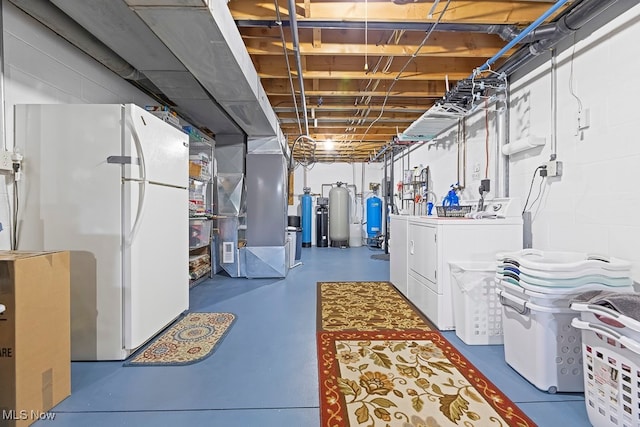 basement with washer and dryer, heating unit, and white refrigerator