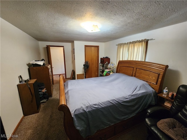 bedroom featuring dark colored carpet and a textured ceiling