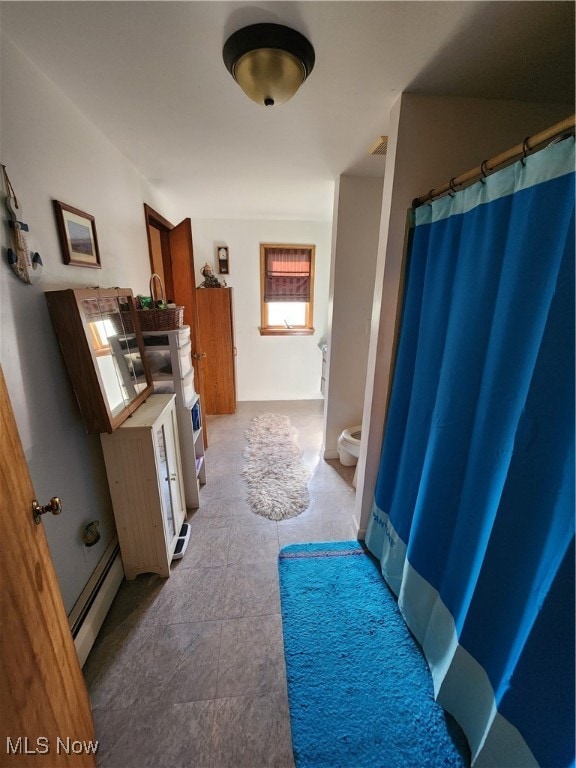 bathroom featuring toilet, tile patterned floors, and a baseboard radiator