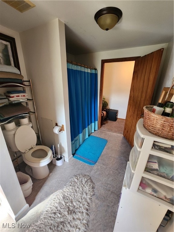 bathroom with toilet and a shower with curtain