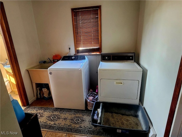 clothes washing area with independent washer and dryer and light tile patterned floors