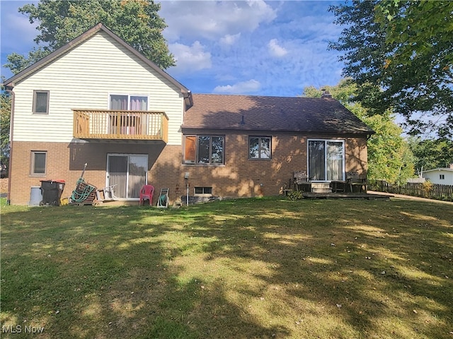 back of house with a balcony and a lawn