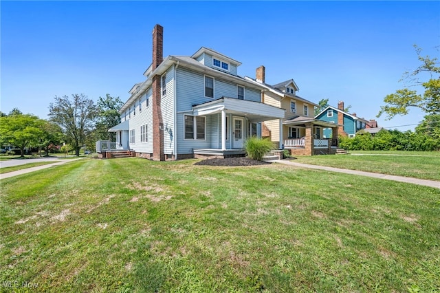 traditional style home featuring a porch, a chimney, and a front yard