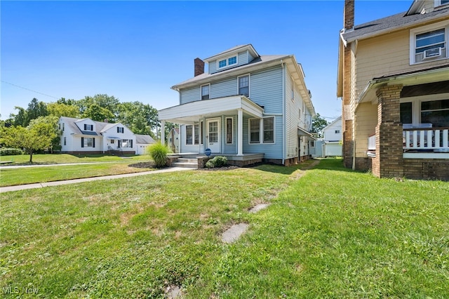 american foursquare style home featuring a porch and a front lawn