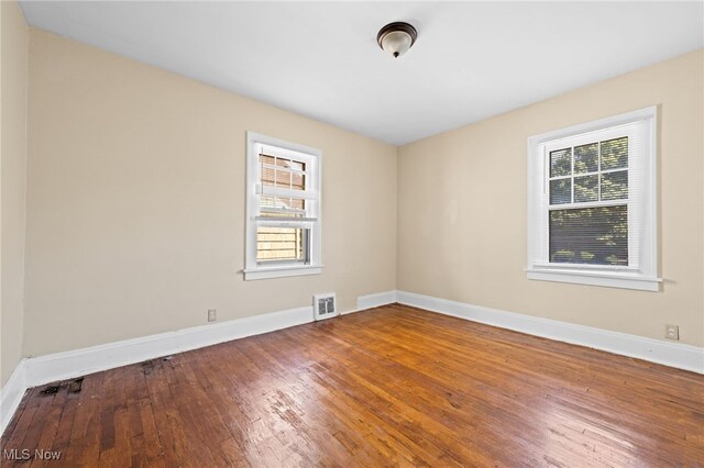 unfurnished room featuring plenty of natural light and hardwood / wood-style floors