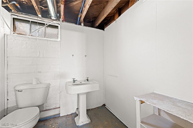 bathroom featuring concrete floors and toilet