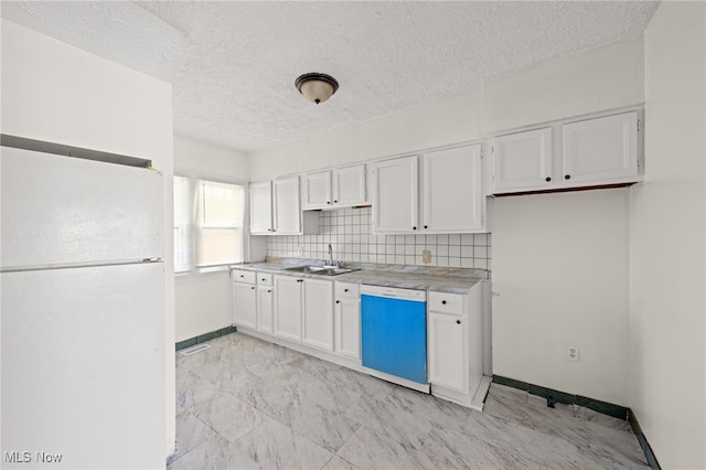 kitchen with light countertops, decorative backsplash, white cabinets, a sink, and white appliances