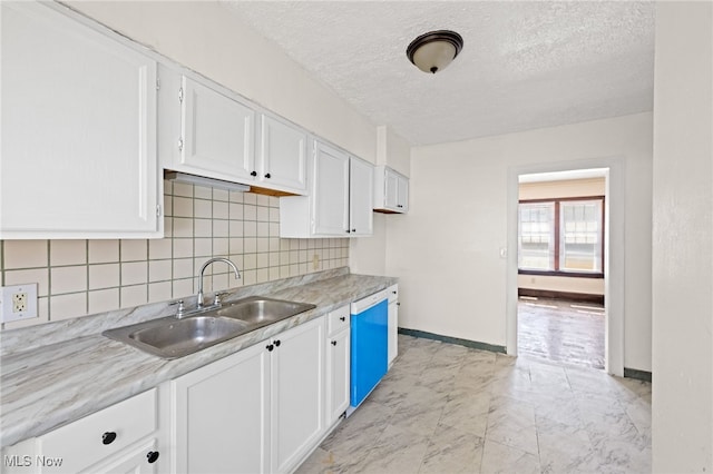 kitchen with marble finish floor, white cabinets, a sink, and white dishwasher