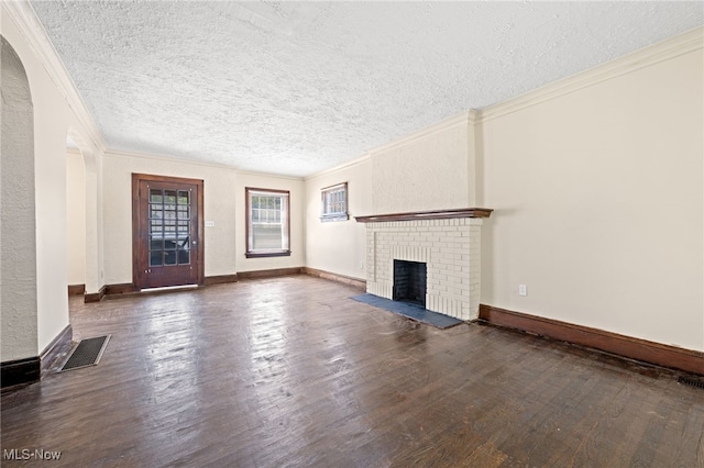 unfurnished living room featuring dark hardwood / wood-style floors, a textured ceiling, and a brick fireplace