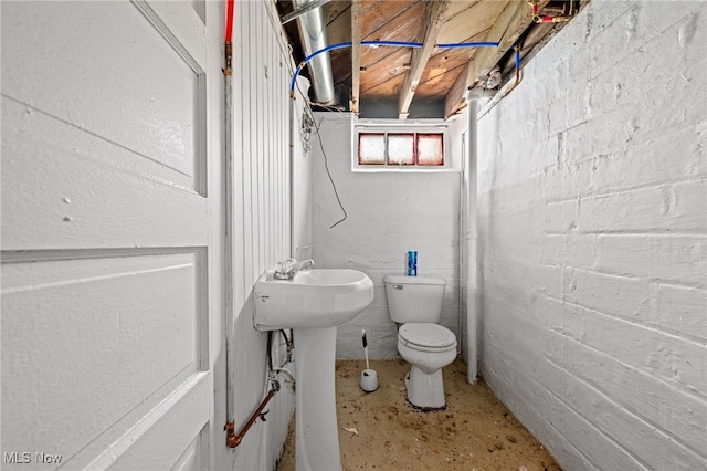 bathroom with toilet and unfinished concrete floors