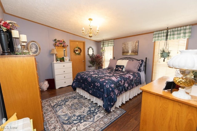 bedroom with a textured ceiling, dark wood-type flooring, ornamental molding, and an inviting chandelier