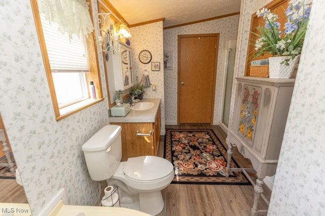 bathroom featuring toilet, crown molding, vanity, lofted ceiling, and hardwood / wood-style flooring