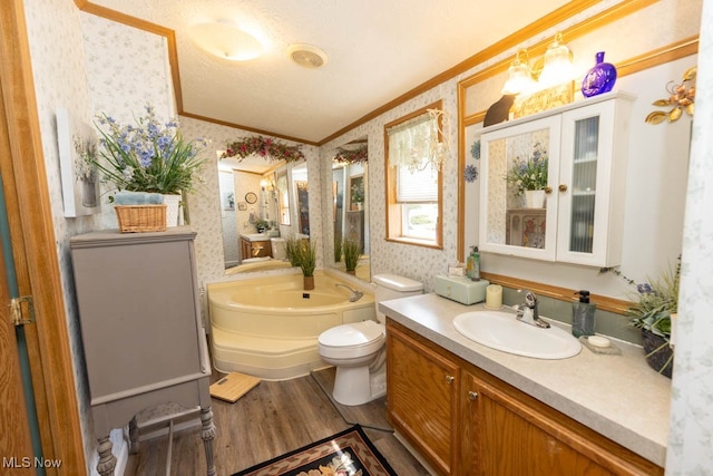 bathroom with vanity, hardwood / wood-style floors, crown molding, toilet, and a bathtub