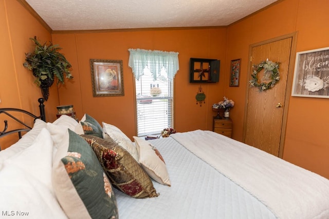 bedroom with crown molding and a textured ceiling