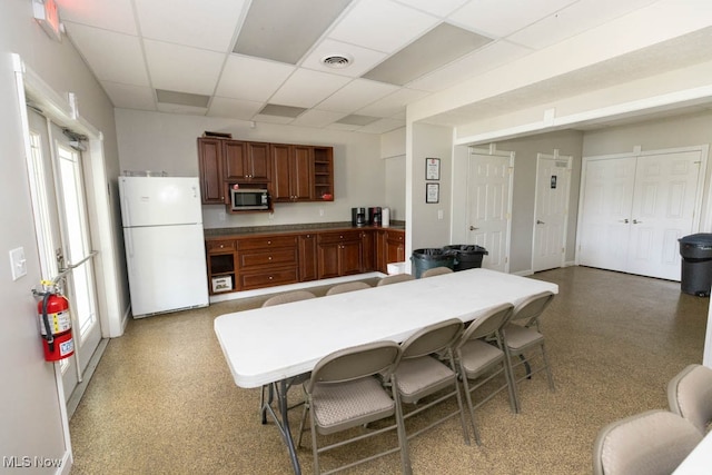 kitchen with a paneled ceiling and white fridge