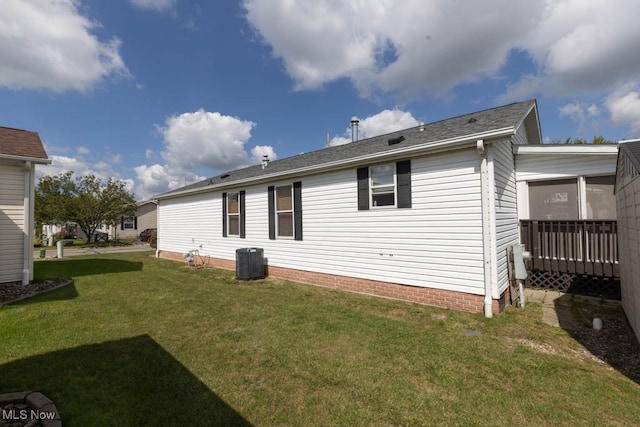 back of property with cooling unit and a lawn