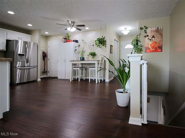 interior space featuring ceiling fan, stainless steel fridge, dark wood-type flooring, and a textured ceiling