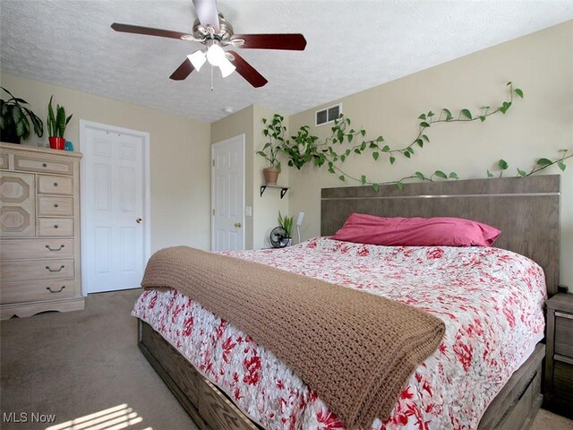 carpeted bedroom featuring a textured ceiling and ceiling fan