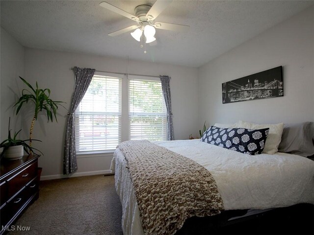 carpeted bedroom with ceiling fan and a textured ceiling