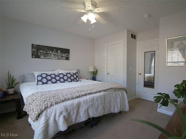 carpeted bedroom featuring ceiling fan and a textured ceiling