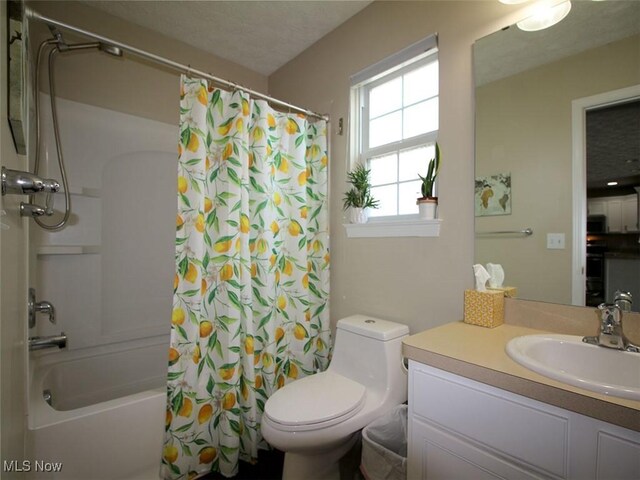 full bathroom featuring shower / bath combo, toilet, a textured ceiling, and vanity