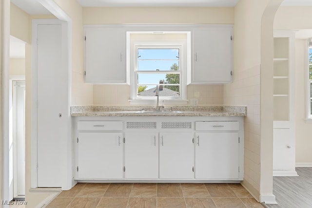 kitchen featuring white cabinetry, tasteful backsplash, and sink