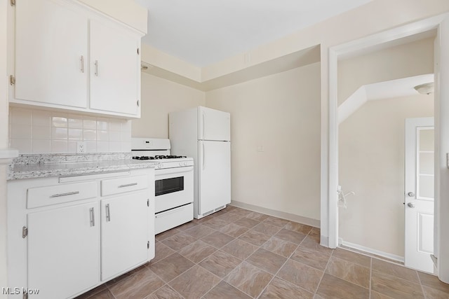 kitchen featuring white appliances, white cabinetry, and tasteful backsplash