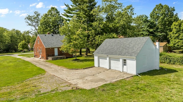 exterior space featuring a lawn, an outdoor structure, and a garage