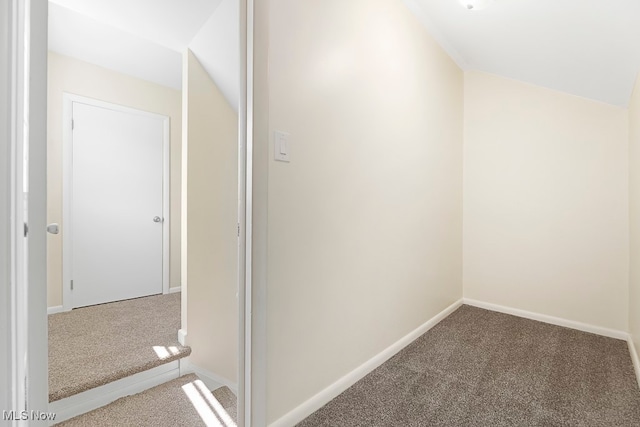 hallway featuring carpet and vaulted ceiling