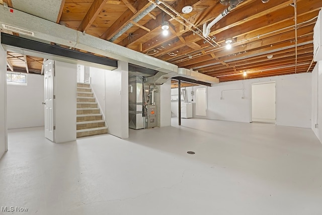 basement featuring heating unit and washer / clothes dryer