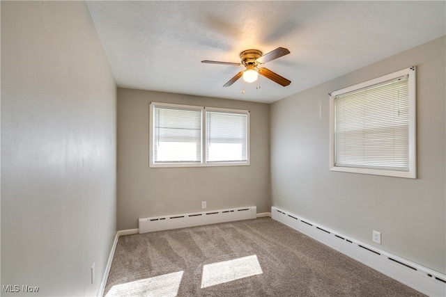 carpeted empty room with a baseboard heating unit and ceiling fan