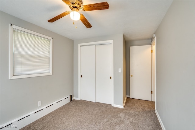 unfurnished bedroom with a baseboard radiator, ceiling fan, a closet, and light colored carpet