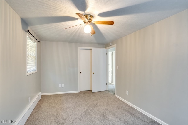 unfurnished room featuring ceiling fan, light colored carpet, and a textured ceiling