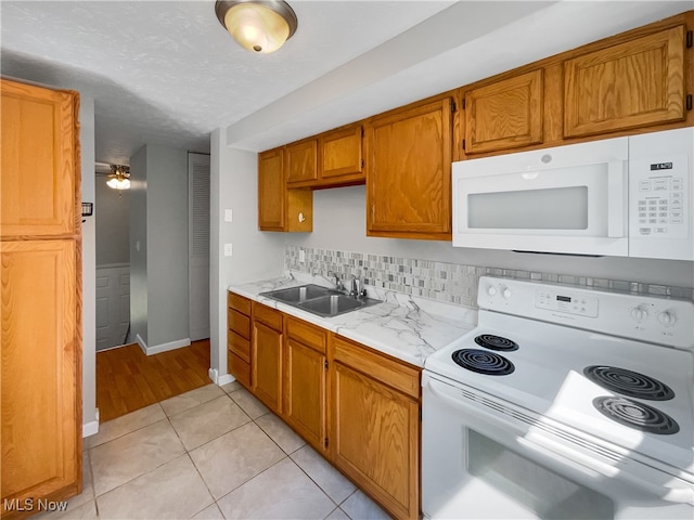 kitchen with white appliances, light hardwood / wood-style flooring, sink, decorative backsplash, and ceiling fan