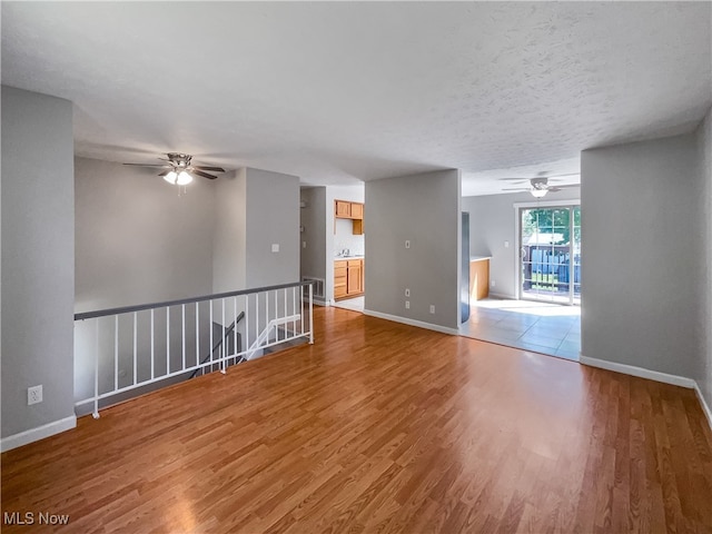 spare room featuring a textured ceiling, ceiling fan, and hardwood / wood-style flooring