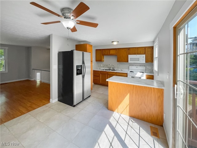 kitchen with white appliances, a wealth of natural light, ceiling fan, and light hardwood / wood-style flooring