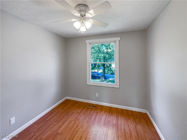 empty room featuring a textured ceiling, ceiling fan, and hardwood / wood-style floors