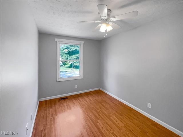 empty room featuring wood-type flooring, a textured ceiling, and ceiling fan