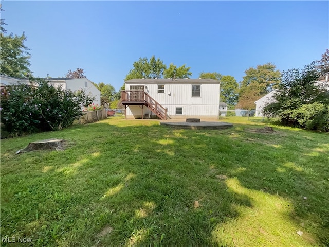 rear view of house with a yard and a wooden deck