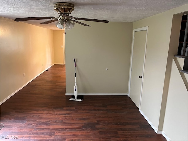 spare room with a textured ceiling, ceiling fan, and dark hardwood / wood-style floors