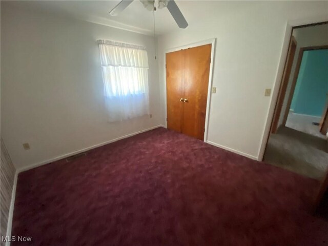 unfurnished bedroom with a closet, ceiling fan, and carpet flooring