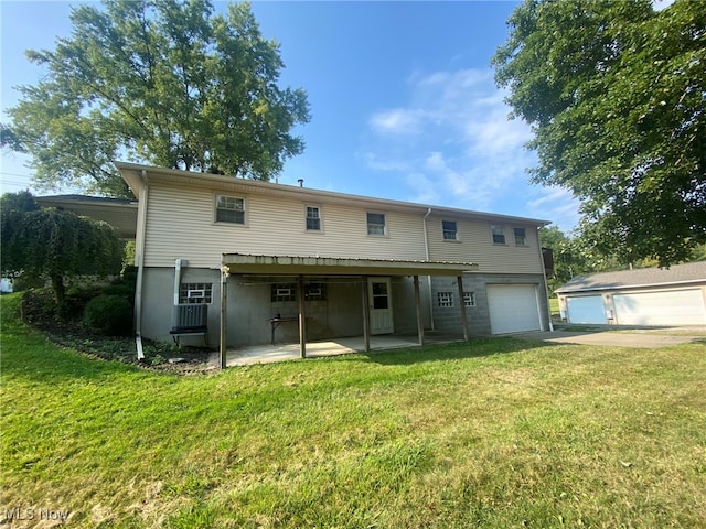 back of house with a garage, a patio area, and a yard