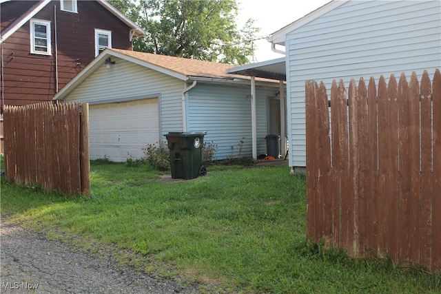 view of side of property featuring a lawn and a garage