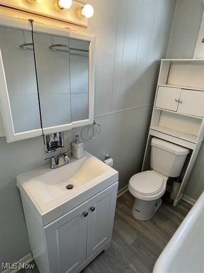 bathroom featuring wood-type flooring, toilet, and vanity