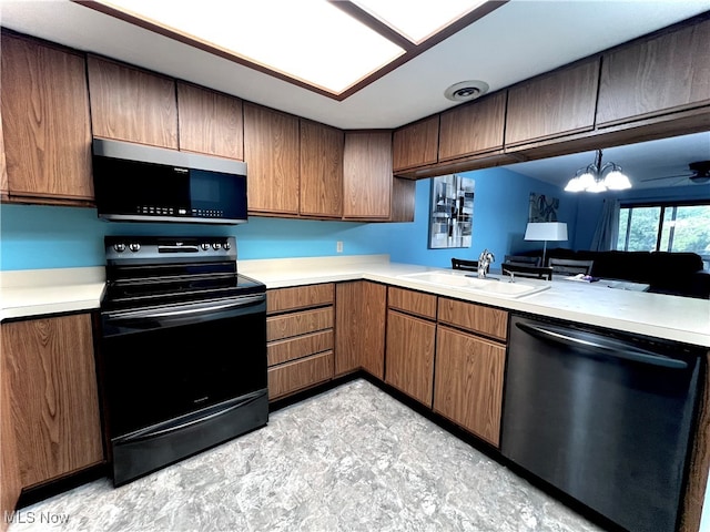 kitchen featuring sink, kitchen peninsula, stainless steel appliances, and a chandelier