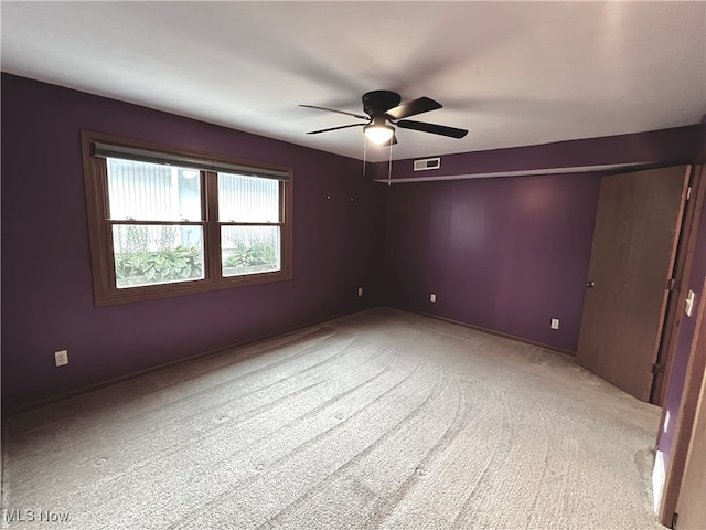 carpeted spare room featuring ceiling fan