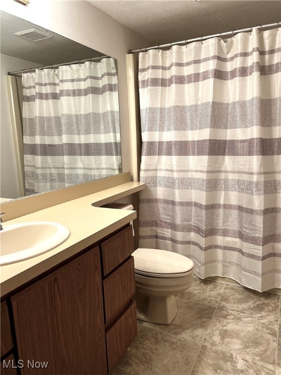 bathroom with vanity, a textured ceiling, and toilet