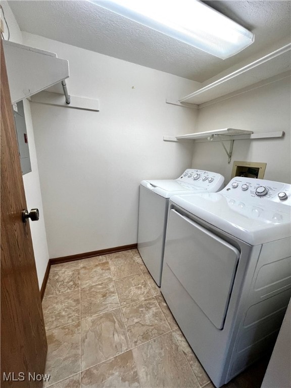 laundry area with a textured ceiling and separate washer and dryer