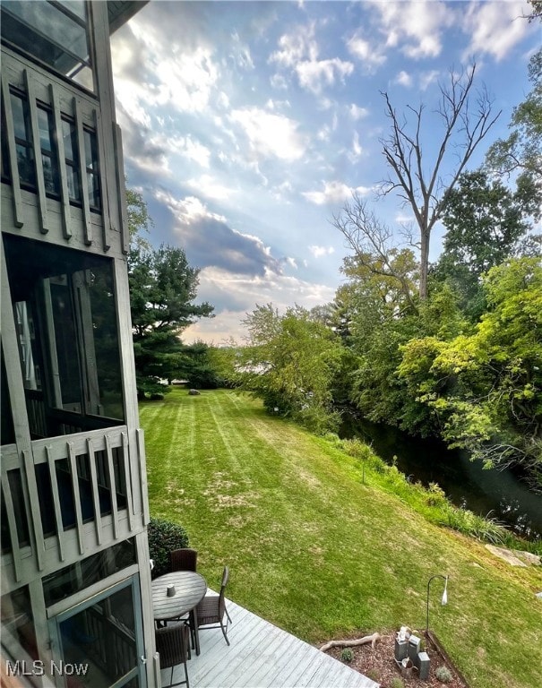 view of yard with a deck with water view